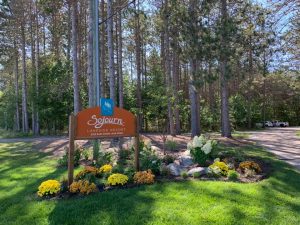 Woodsy entrance to family reunion rental sleeps 50 in Michigan